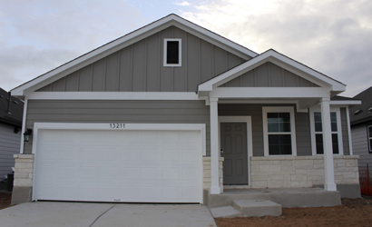 A white garage with a garage with American Gothic House in the background.