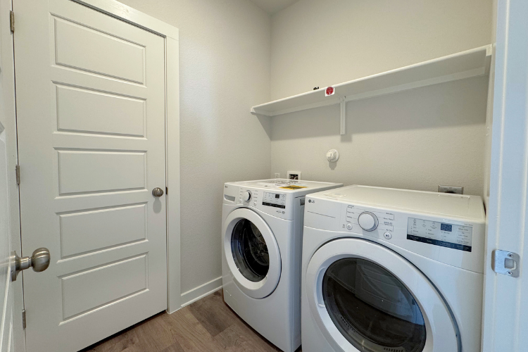 A white laundry room with a white washer and dryer.