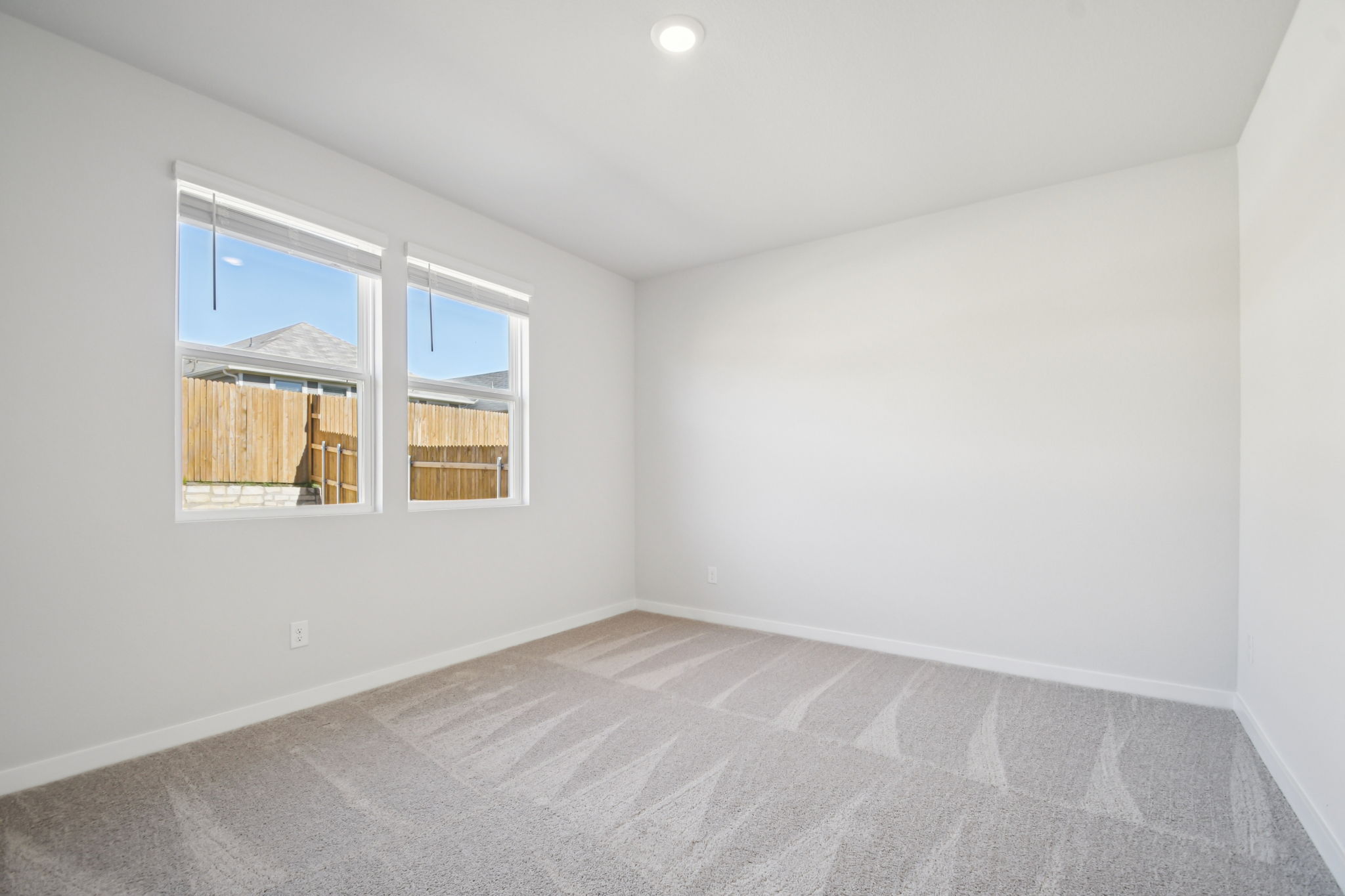 A room with a window and a rug.