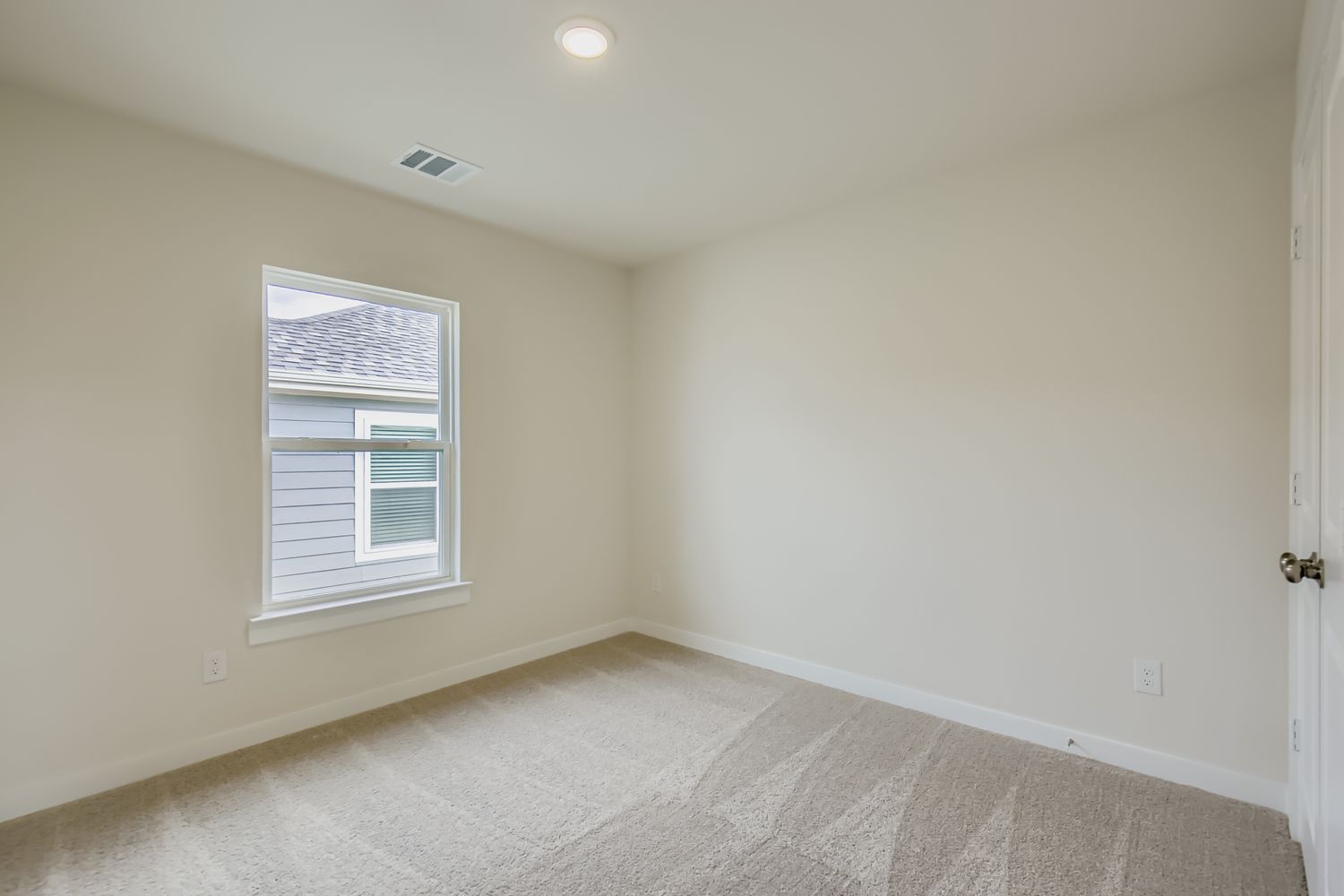 A room with a carpet and a window.