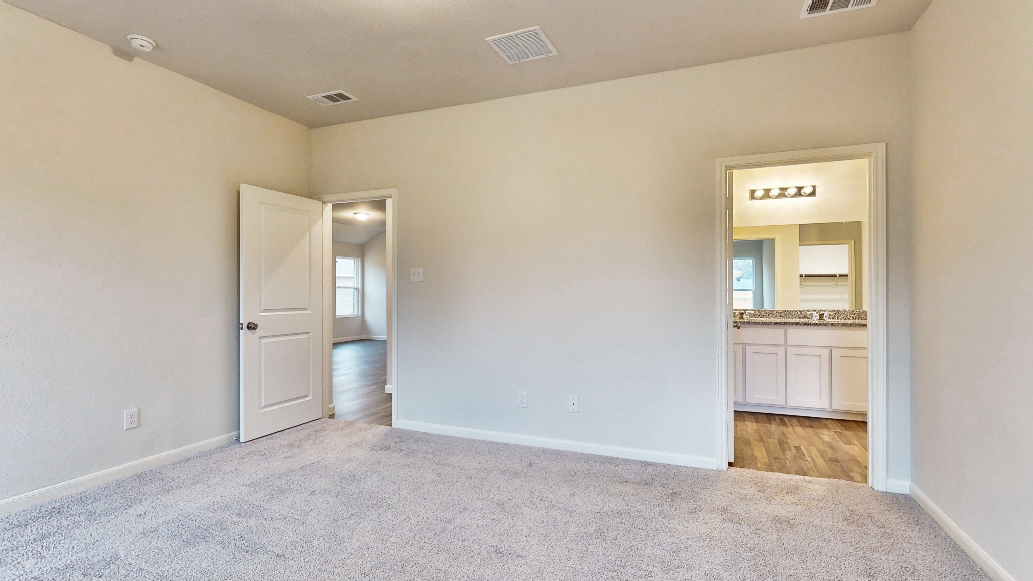 A room with a carpet and a mirror.