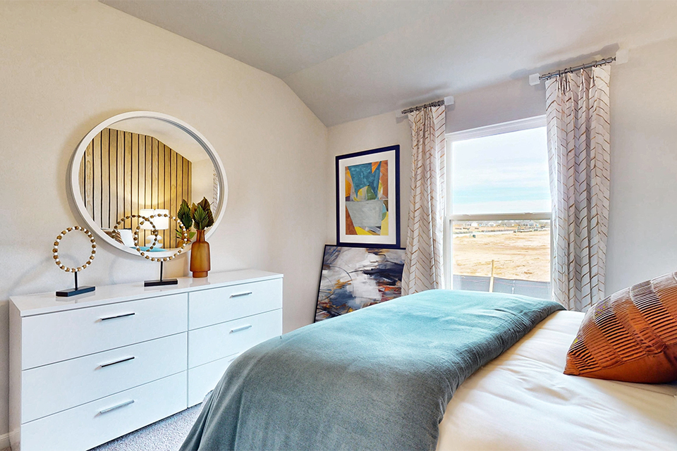 A bedroom with a large mirror.