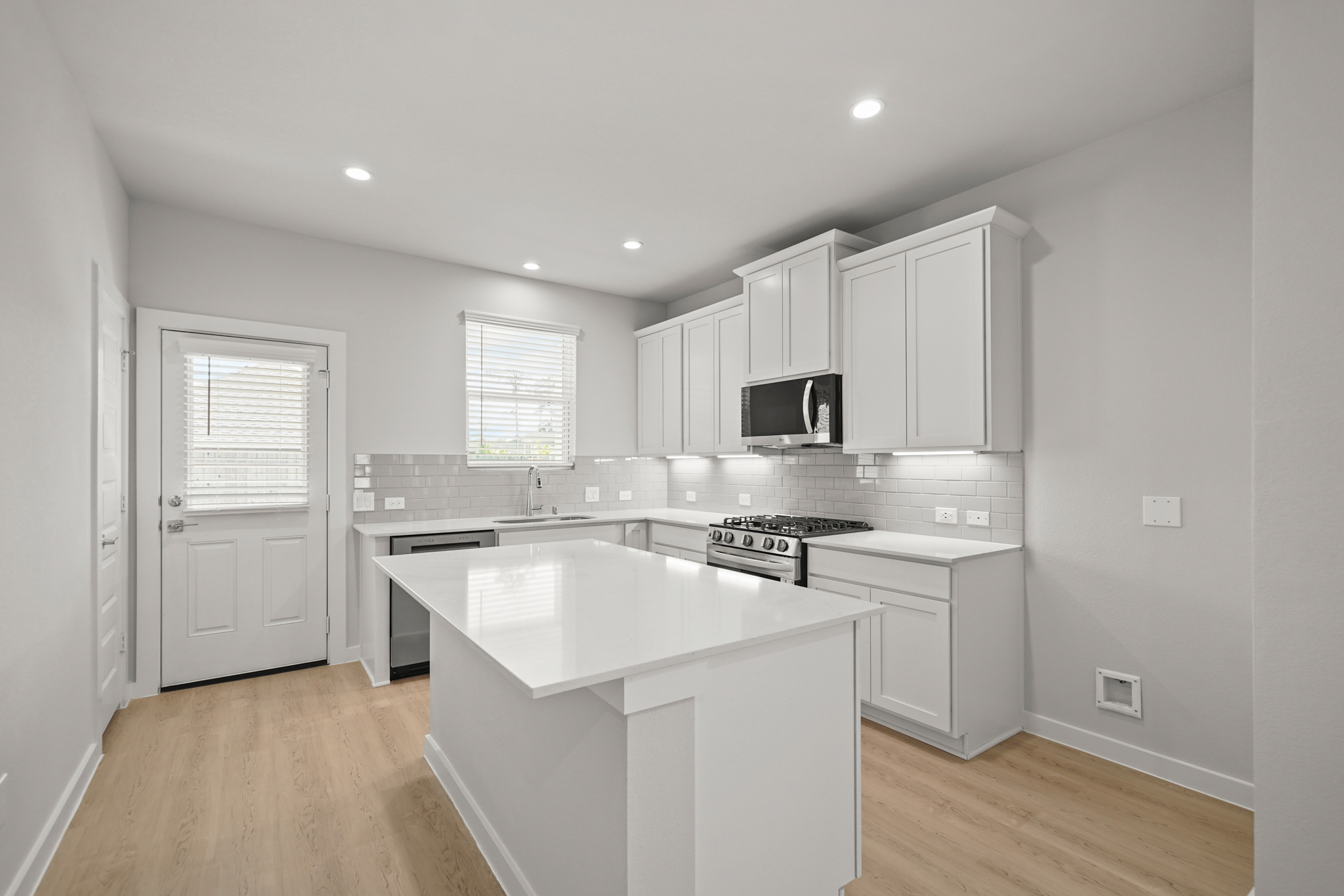 A kitchen with white cabinets.