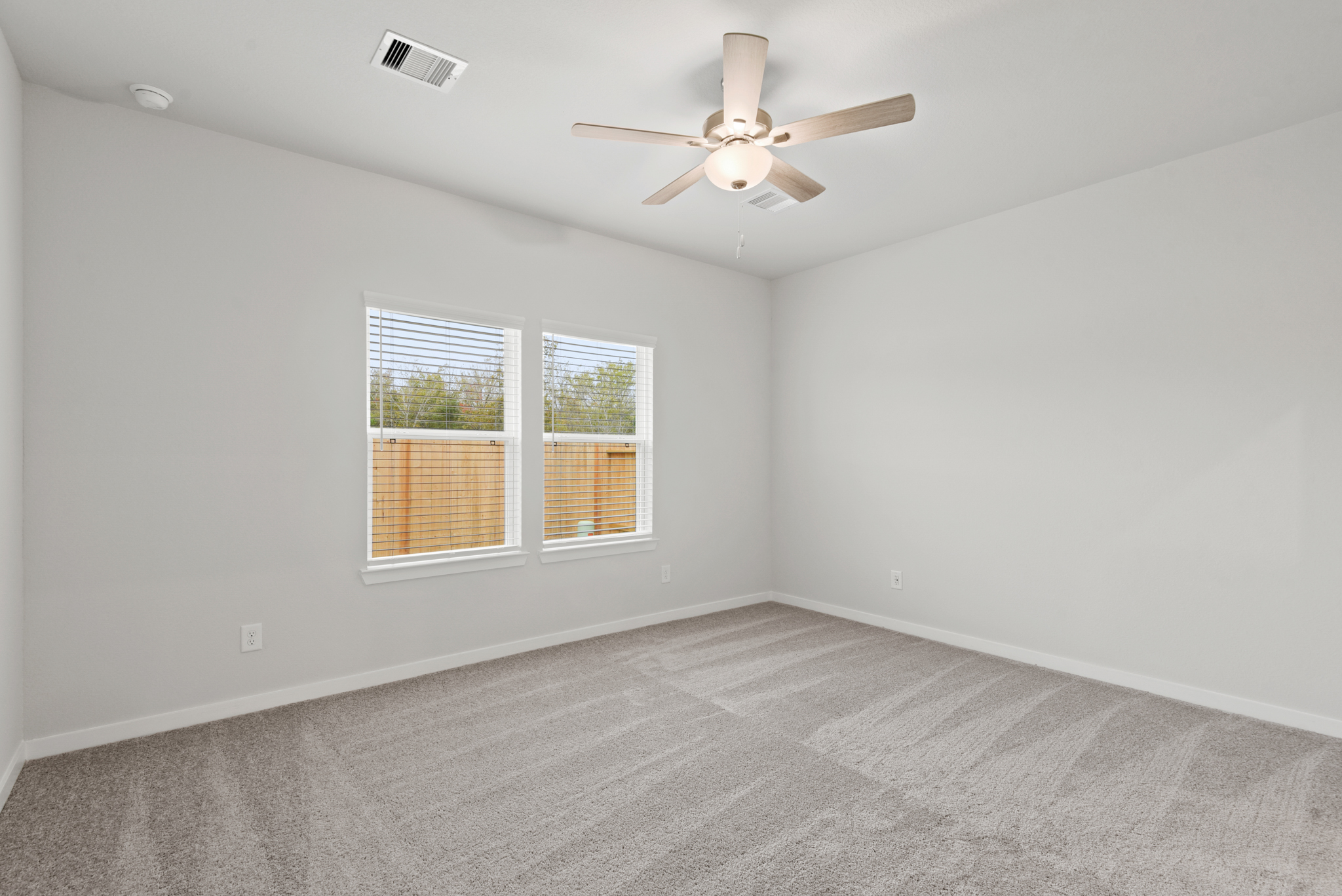 A room with a ceiling fan and a window.