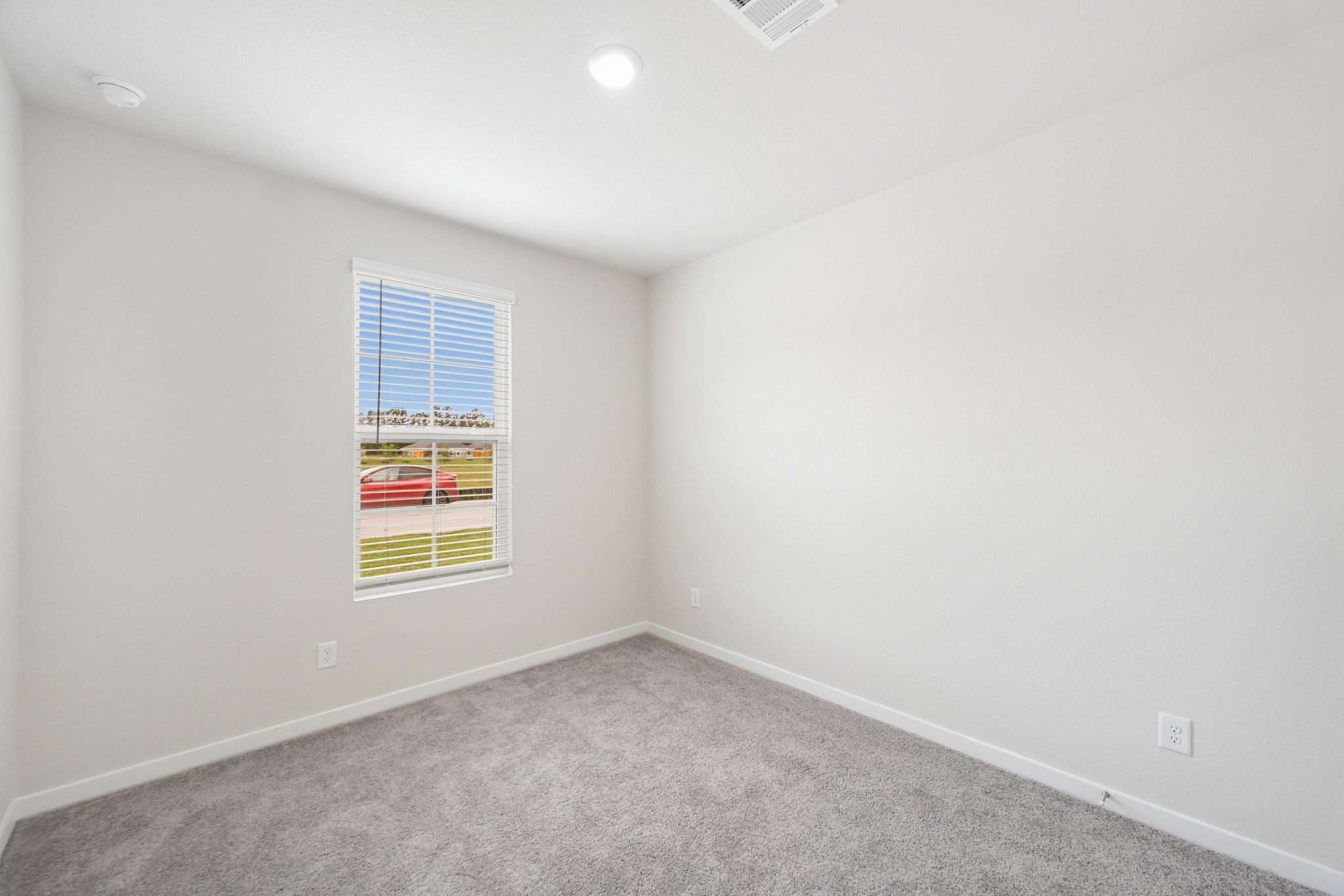 A room with a window and a carpet.