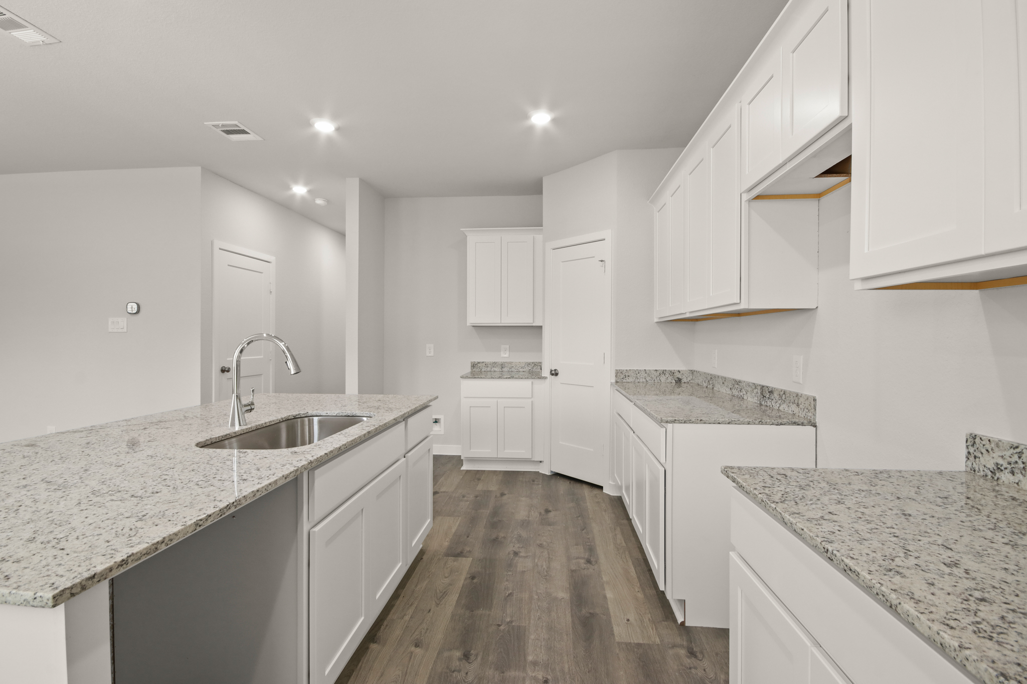 A kitchen with white cabinets.