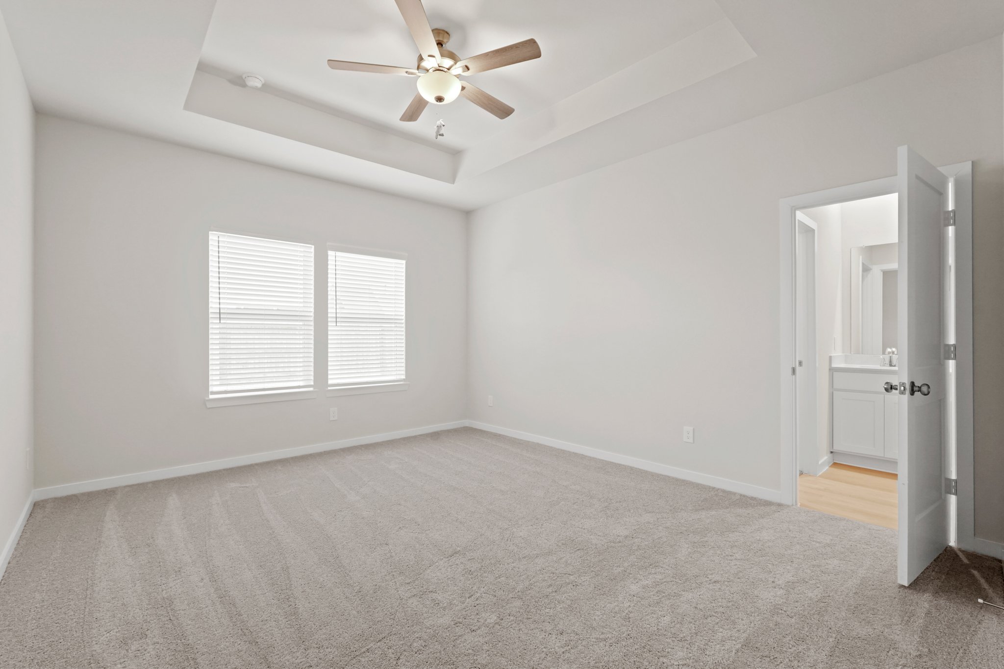A room with a ceiling fan and a door.