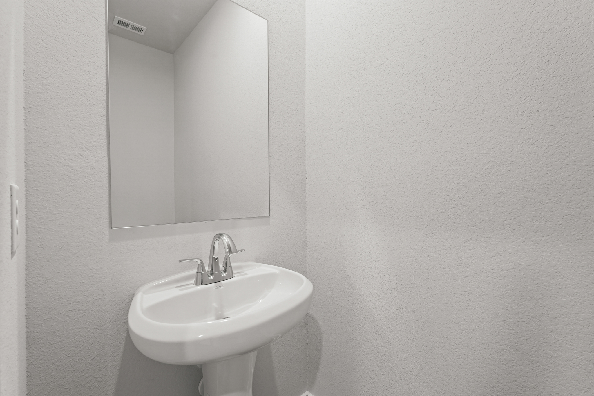 A bathroom with a mirror and sink.