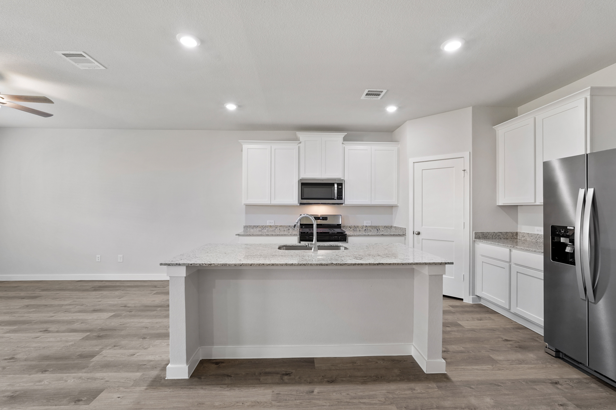 A kitchen with white cabinets.