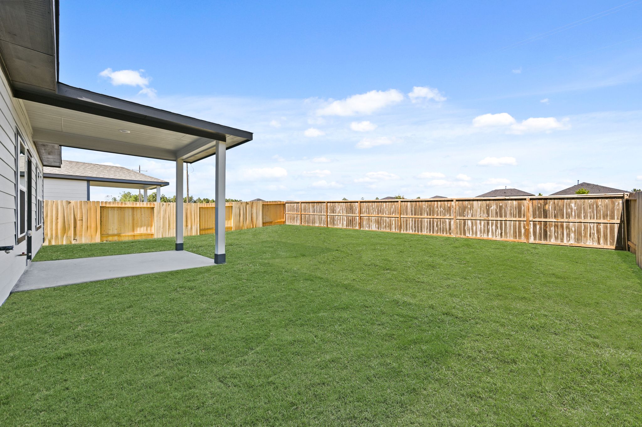 A green lawn next to a fence.