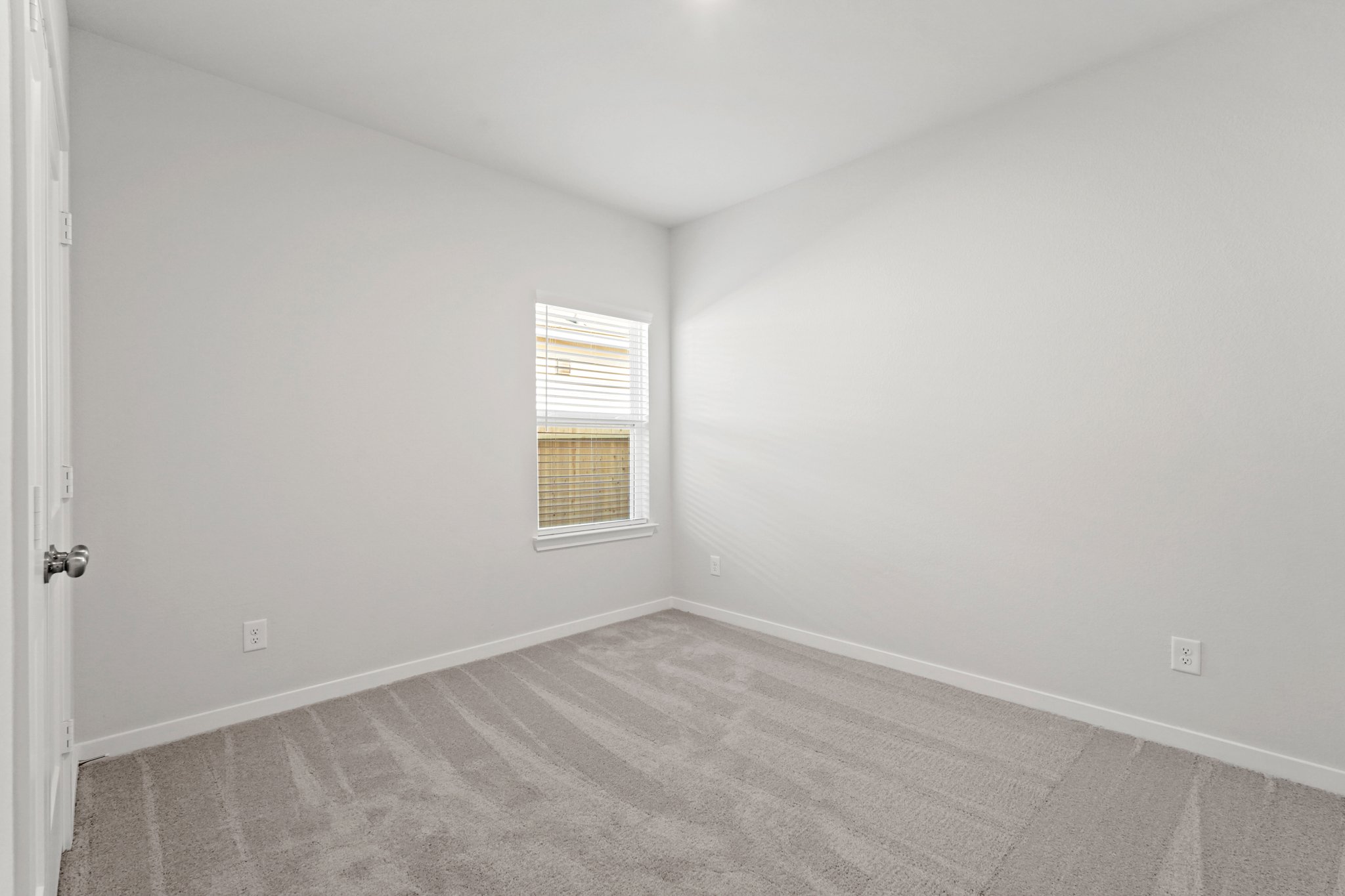 A room with a carpet and a window.