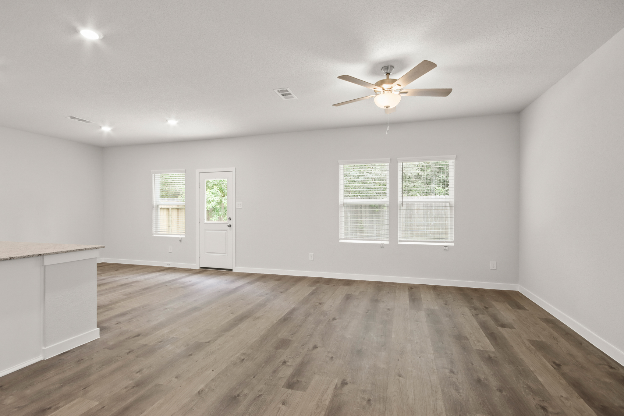 A room with a wood floor and a ceiling fan.