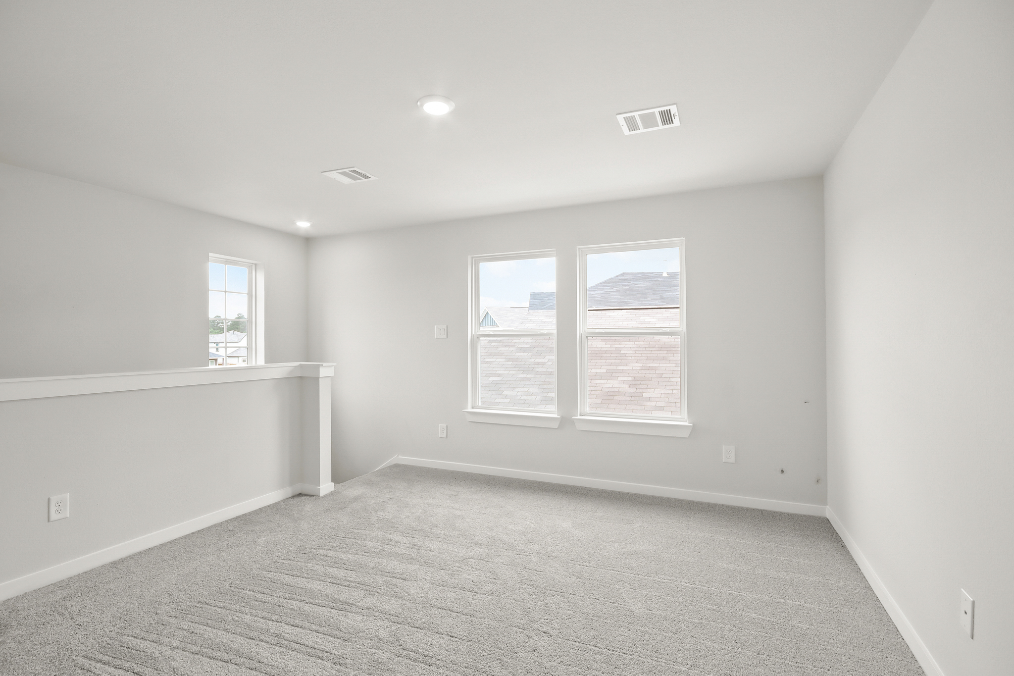 A room with a carpet and windows.