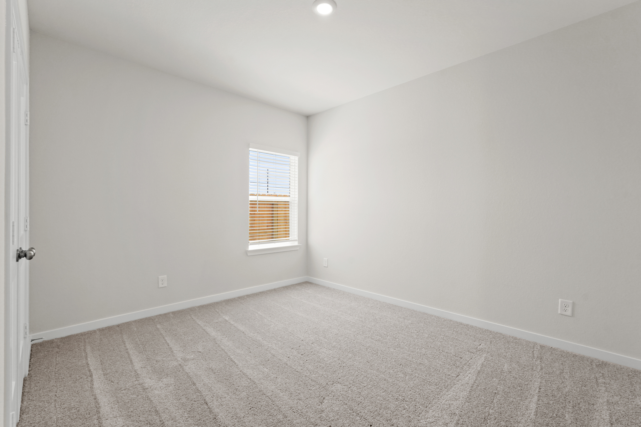 A room with a window and a carpet.