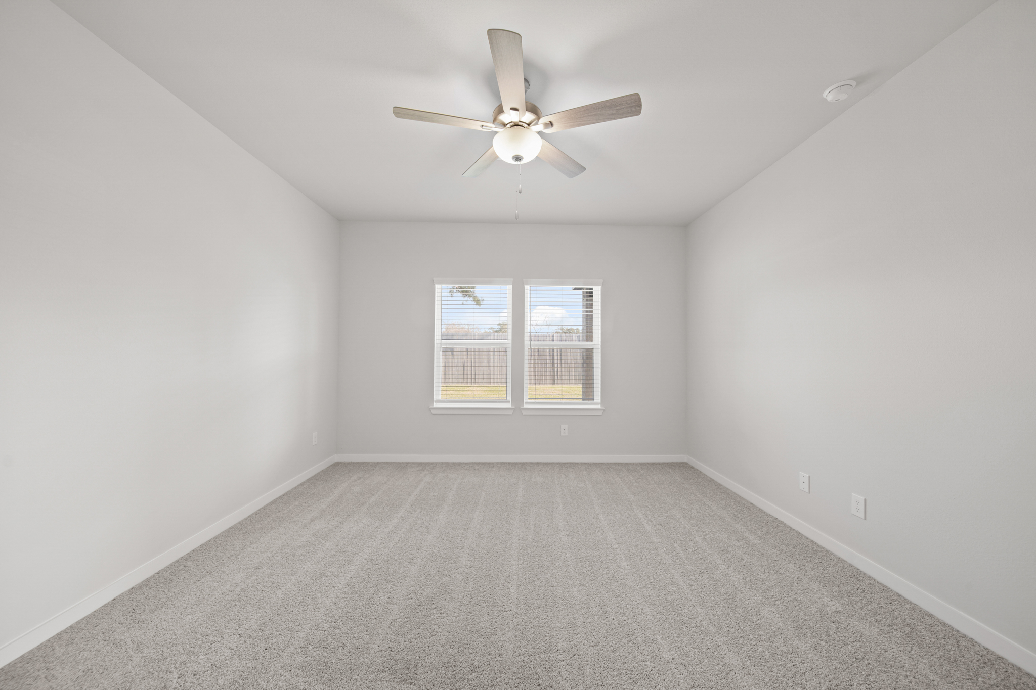 A room with a ceiling fan and a window.