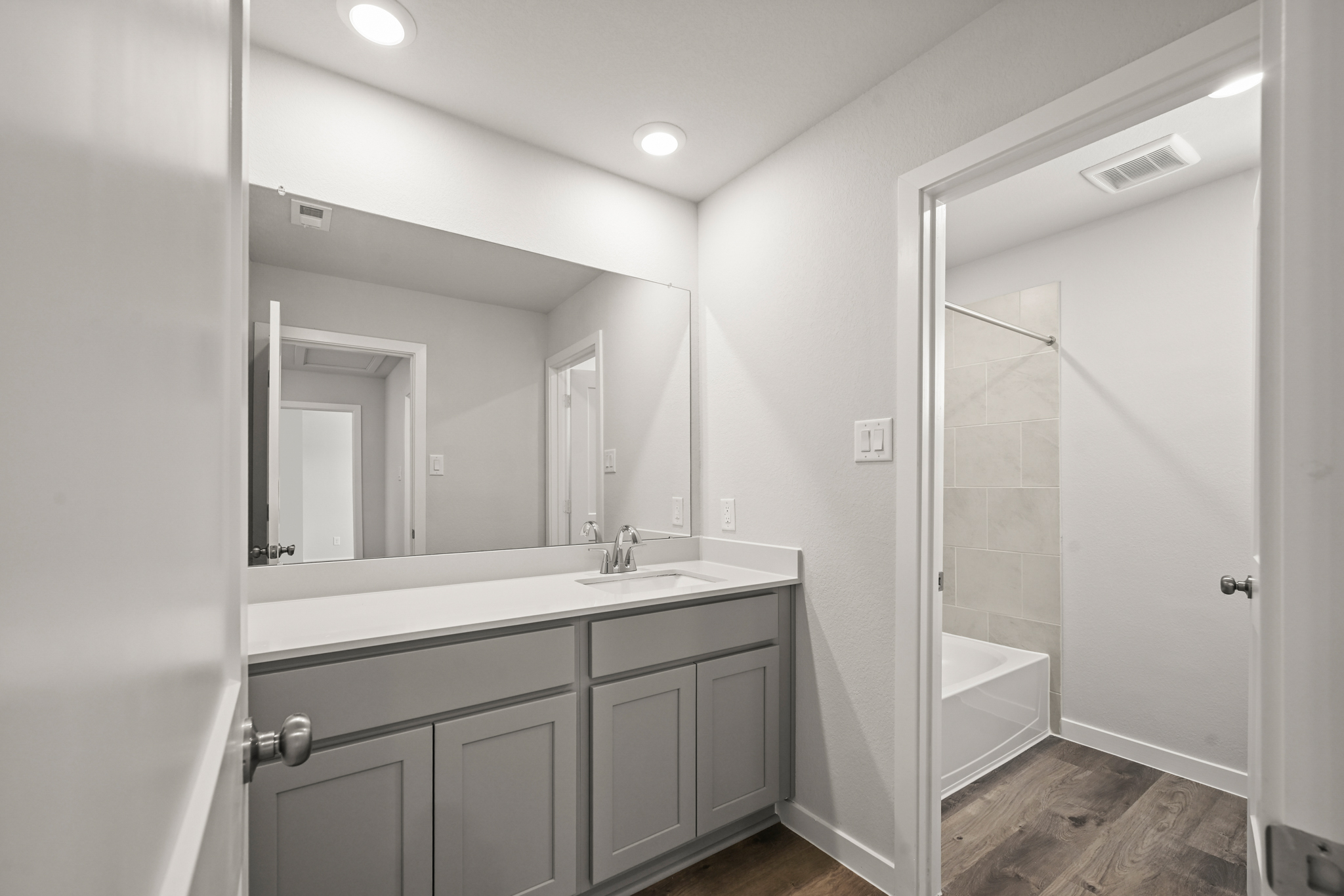 A bathroom with a sink and a shower unit.