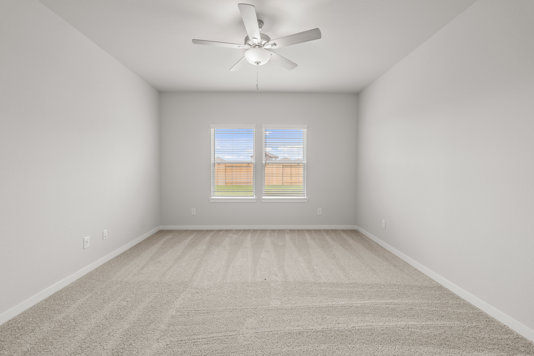 A room with a ceiling fan and a window.