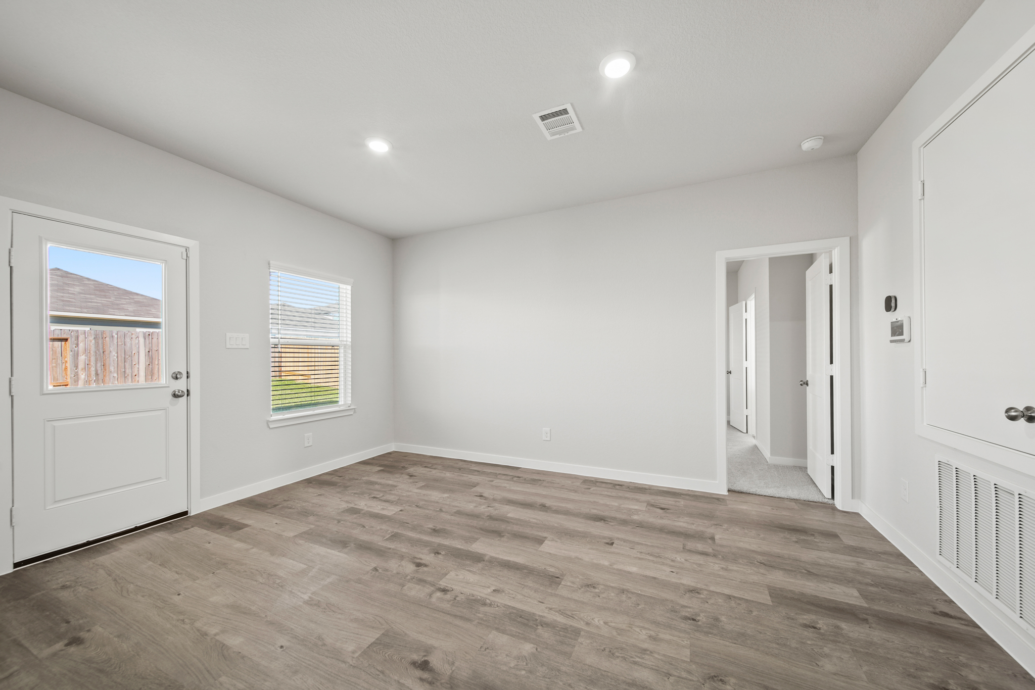 A room with white walls and wood floors.