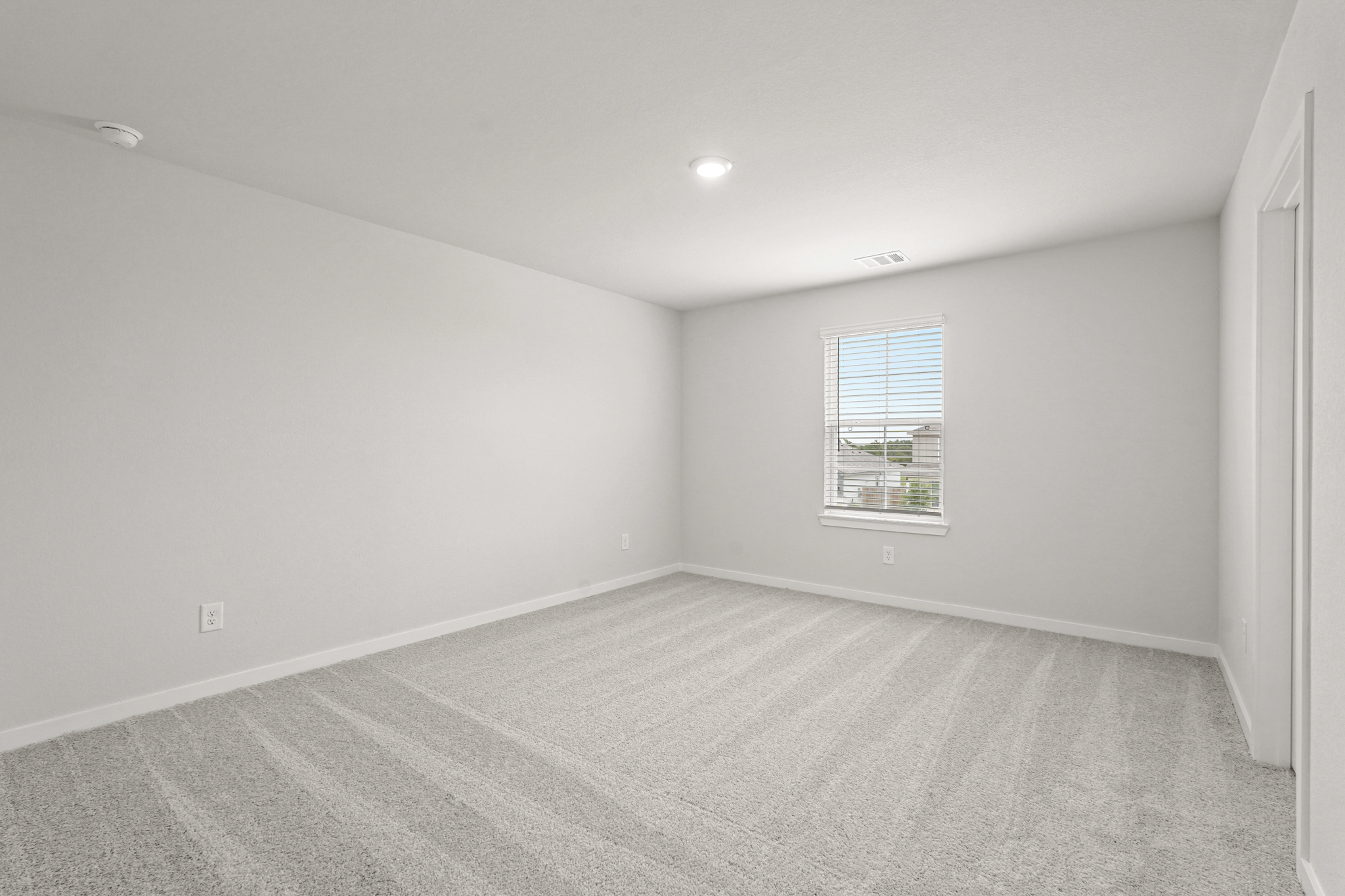 A room with a window and a carpet.