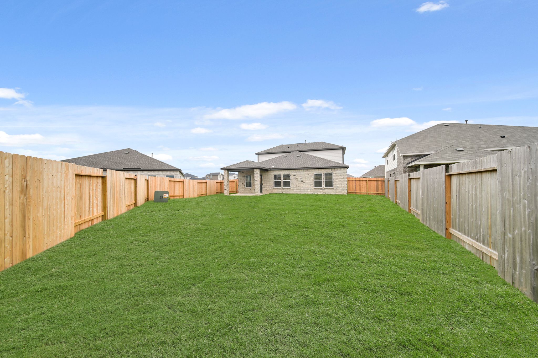 A grassy area with buildings in the background.