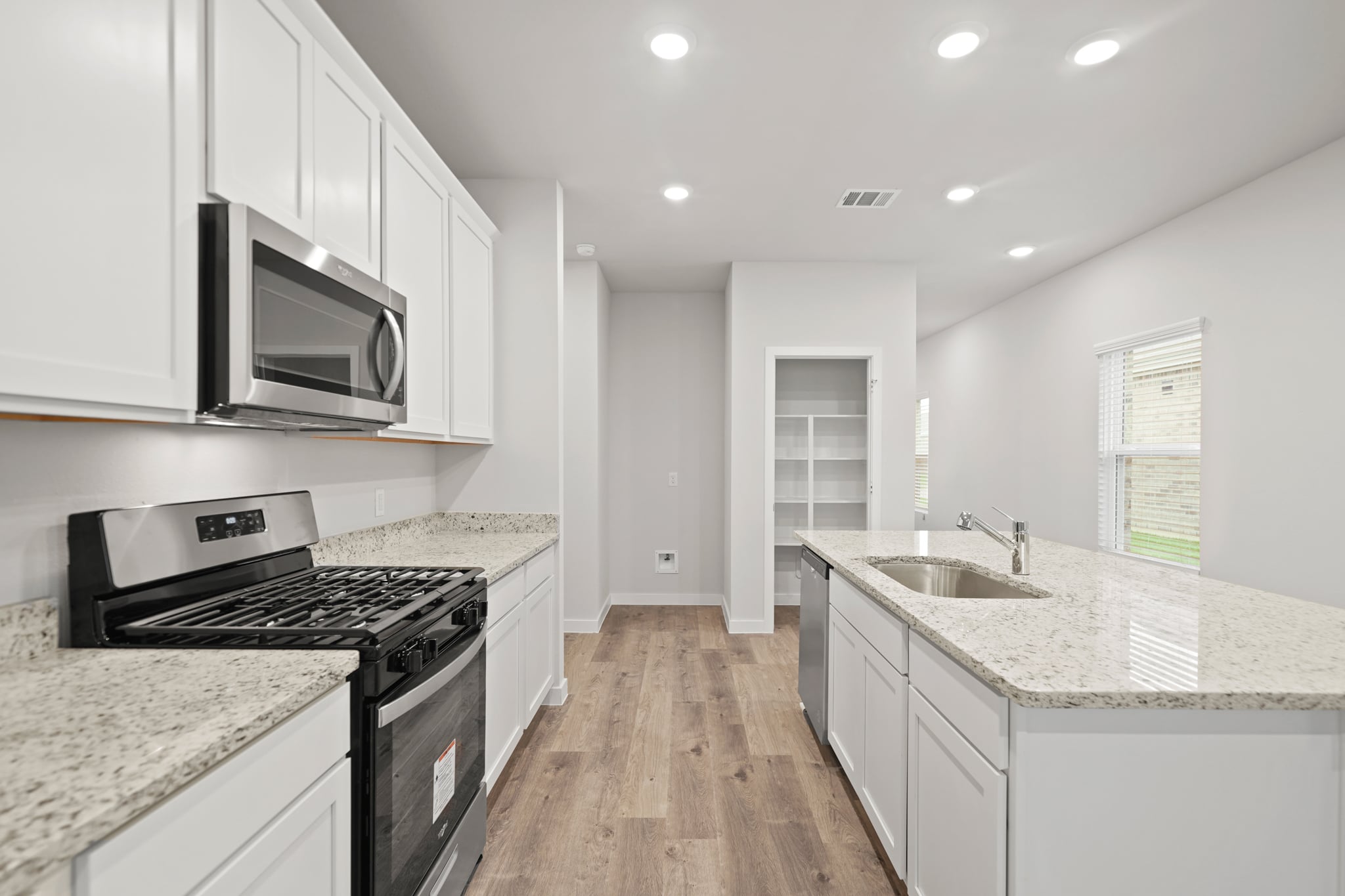 A kitchen with white cabinets.
