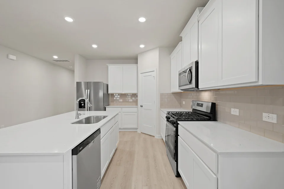 A kitchen with white cabinets.