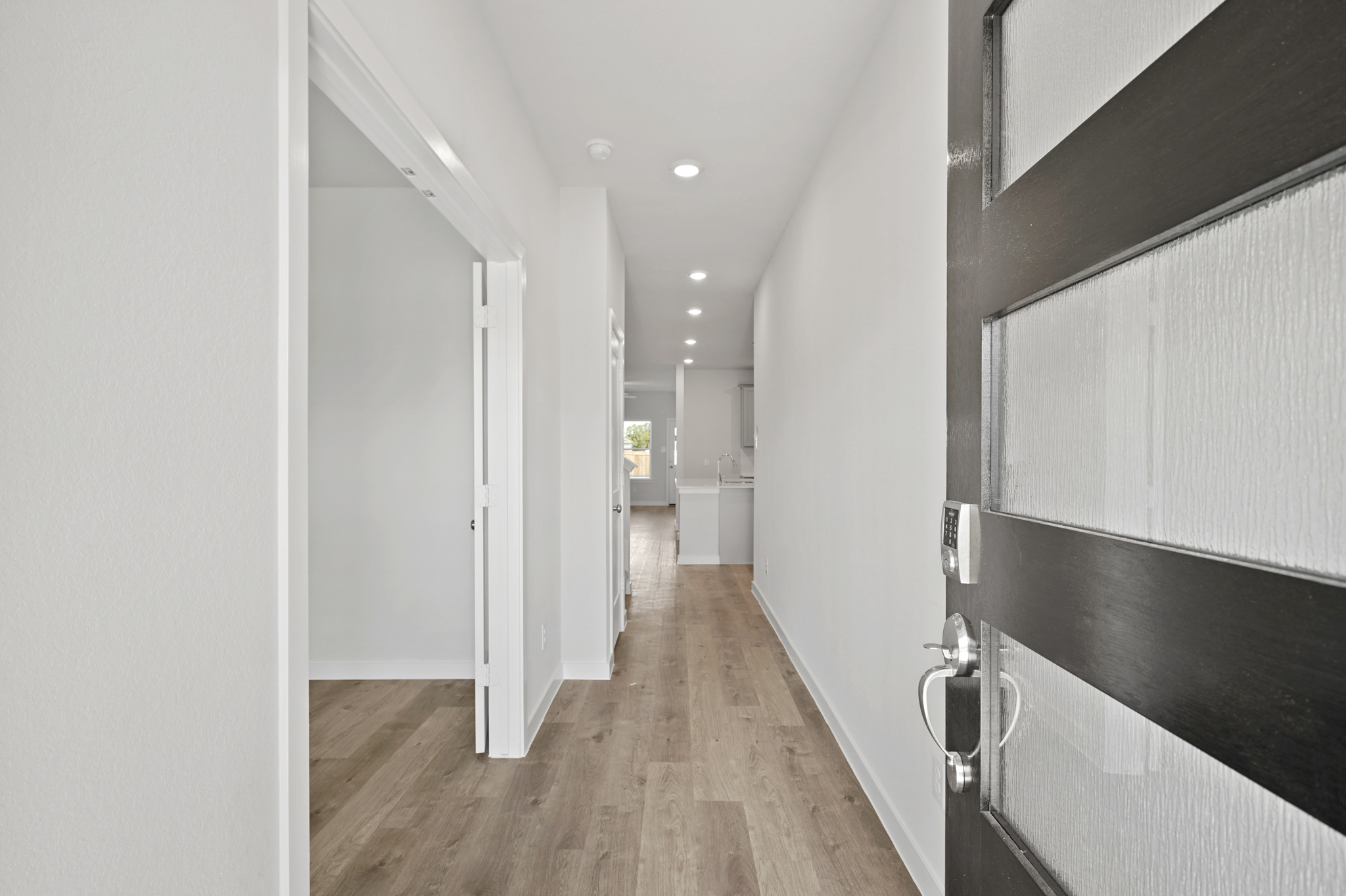 A hallway with black cabinets.