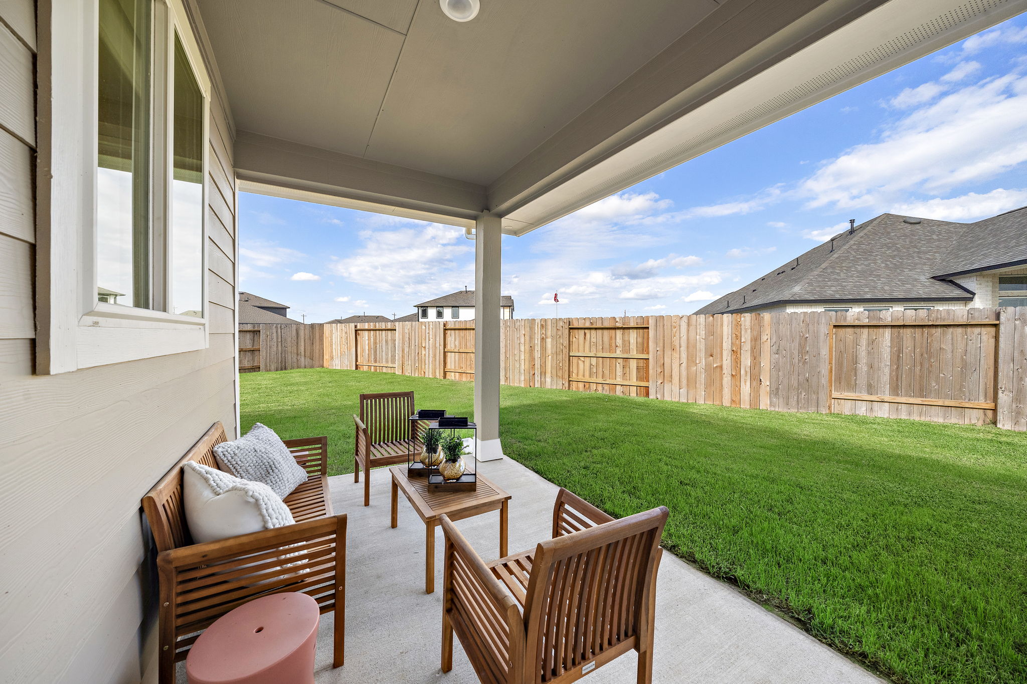 A patio with chairs and a table.