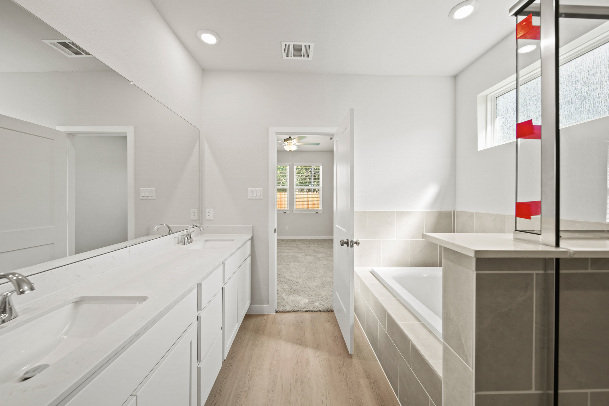 A bathroom with a tub sink and a mirror.