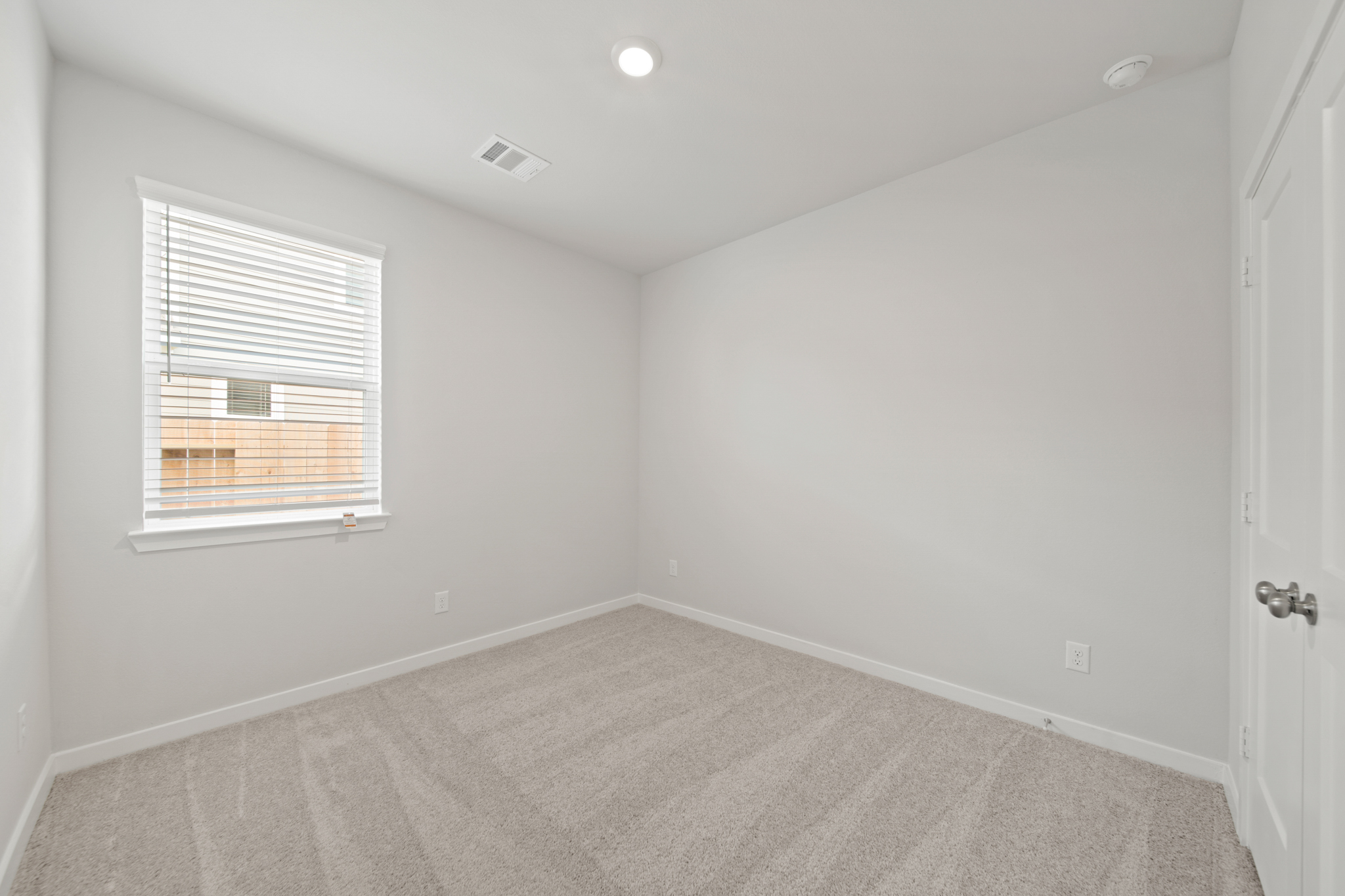 A room with a carpet and a window.