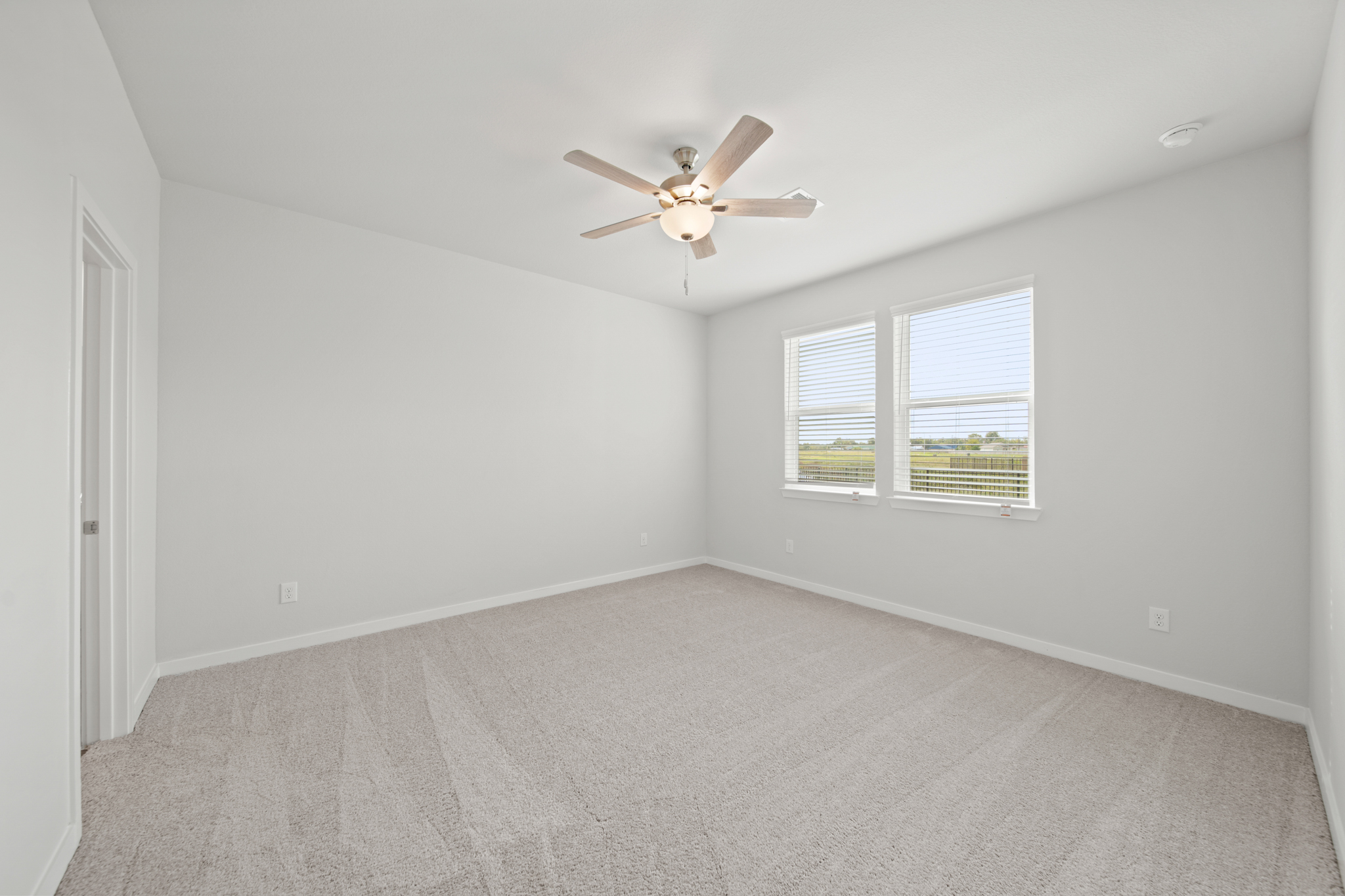 A room with a ceiling fan and a window.