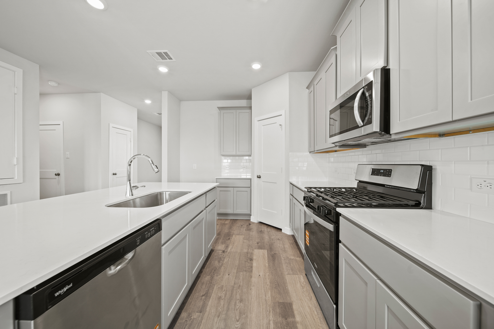 A kitchen with white cabinets.