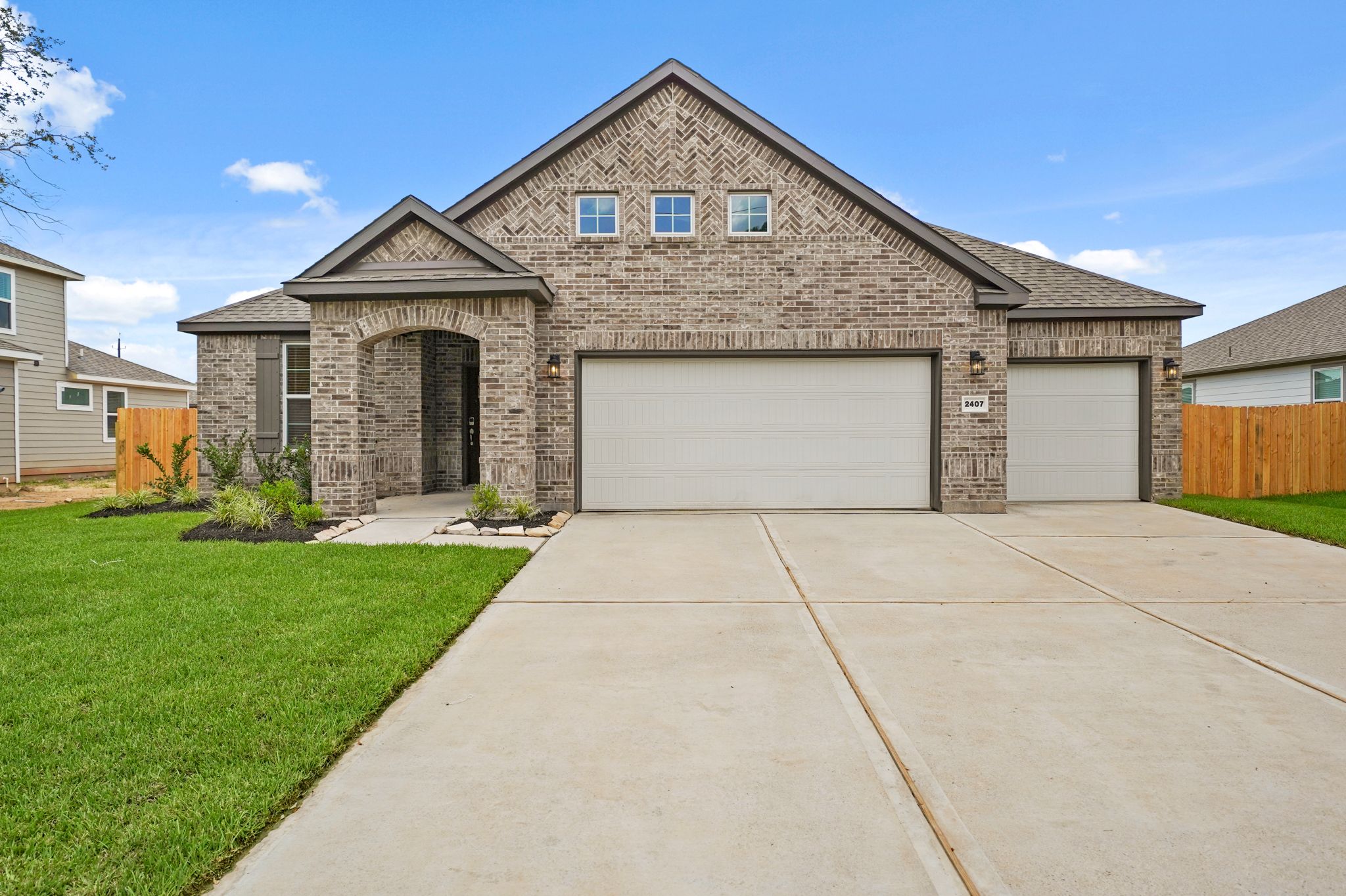 A house with garages and grass.