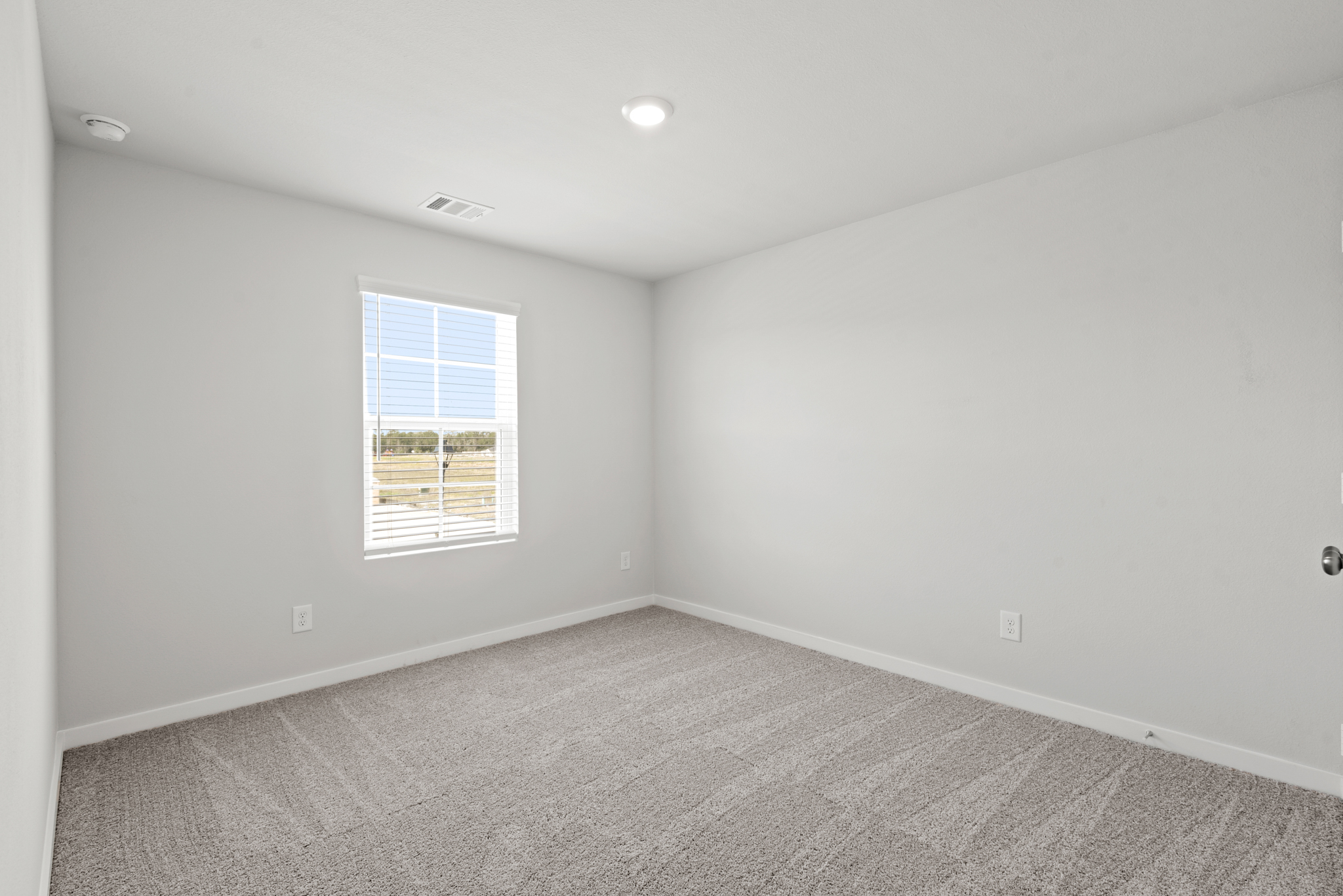 A room with a window and carpet.