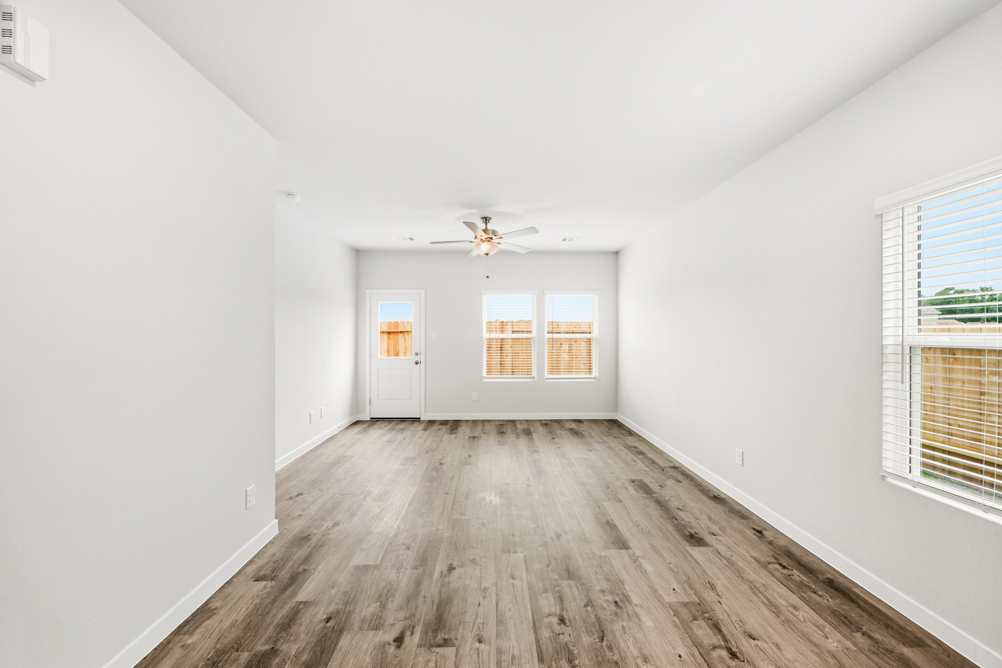 A room with a wood floor and a ceiling fan.