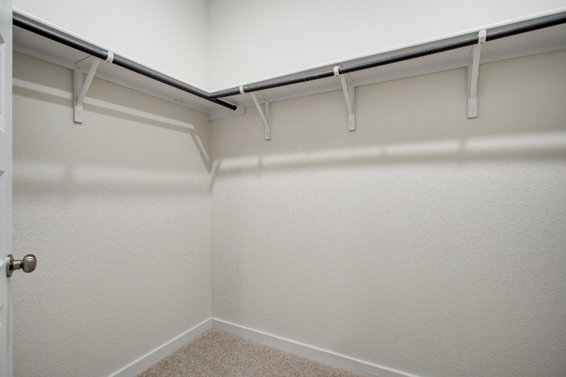 A white wall with a metal railing.