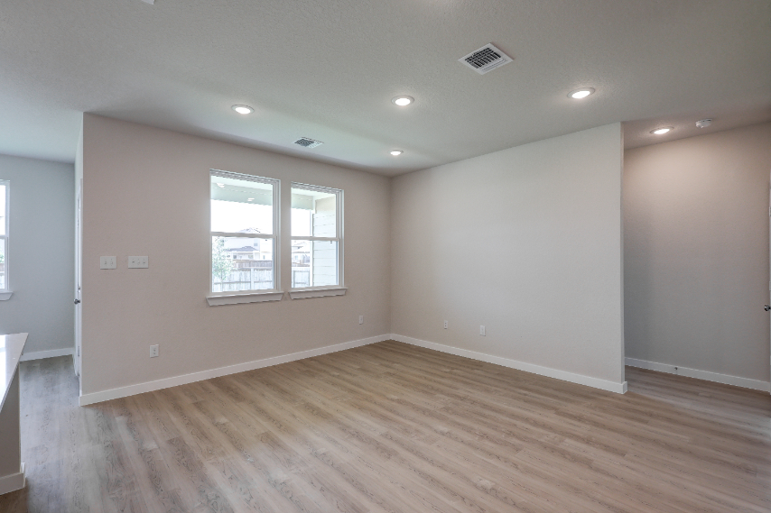 A room with a wood floor and a wood floor with a window.
