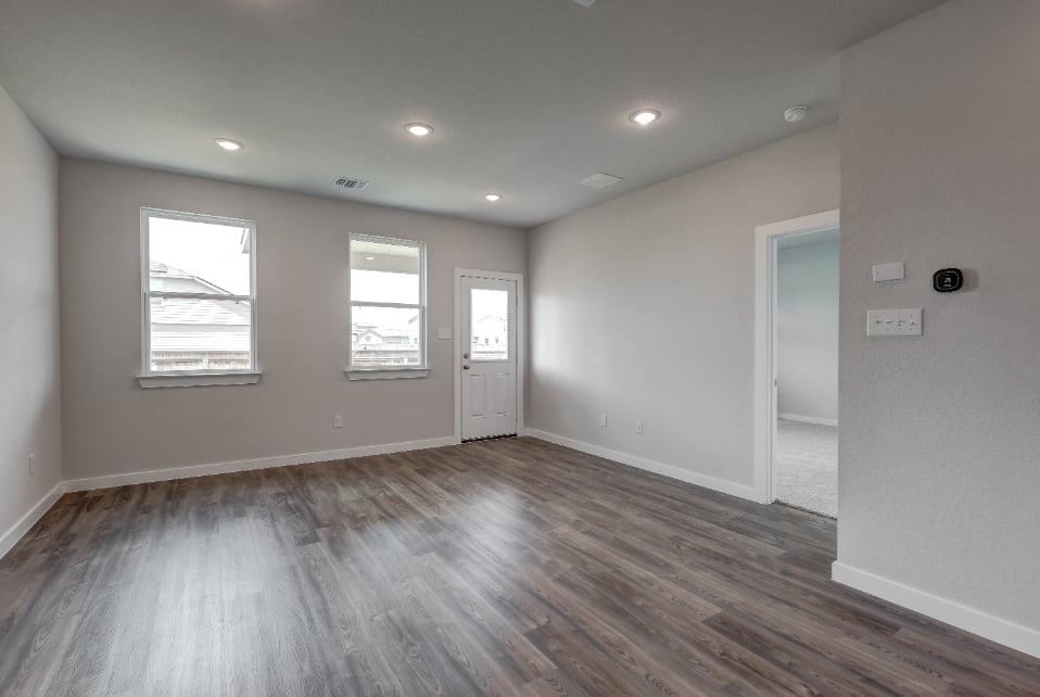 A room with a wood floor and white walls.
