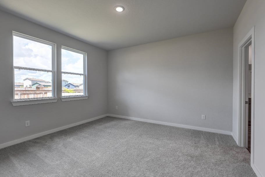 A room with a window and a carpet.