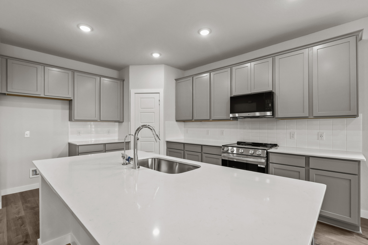 A kitchen with white cabinets.