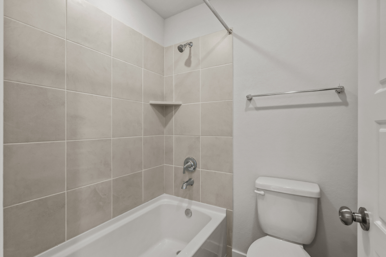 A bathroom with a toilet and bathtub.