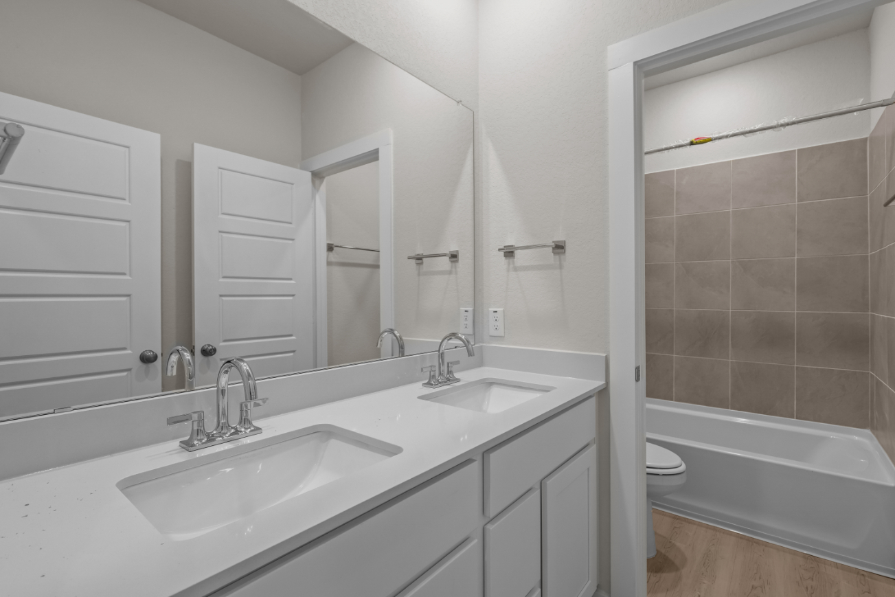 A bathroom with a tub sink and a toilet.