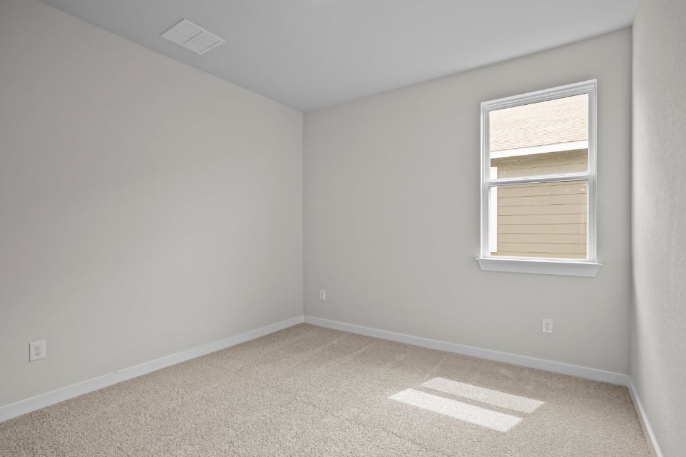 A room with a window and carpet.