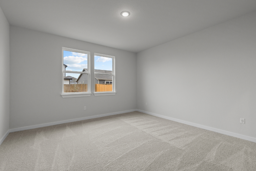 A room with a window and a rug.