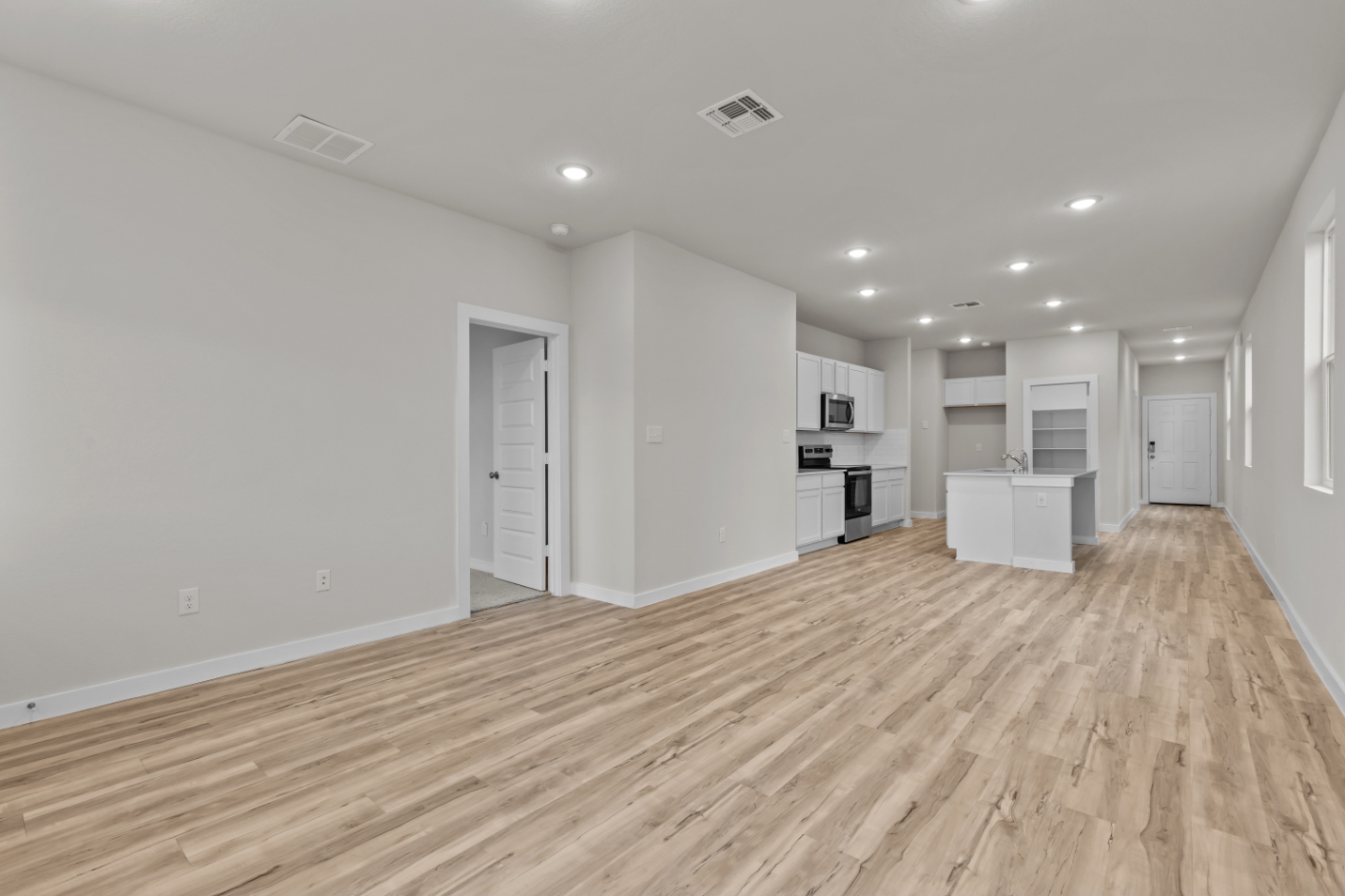 A room with white walls and wood floors.