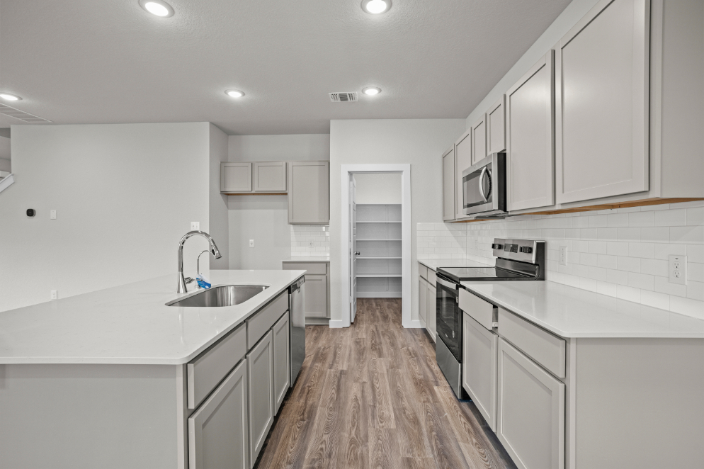 A kitchen with white cabinets.