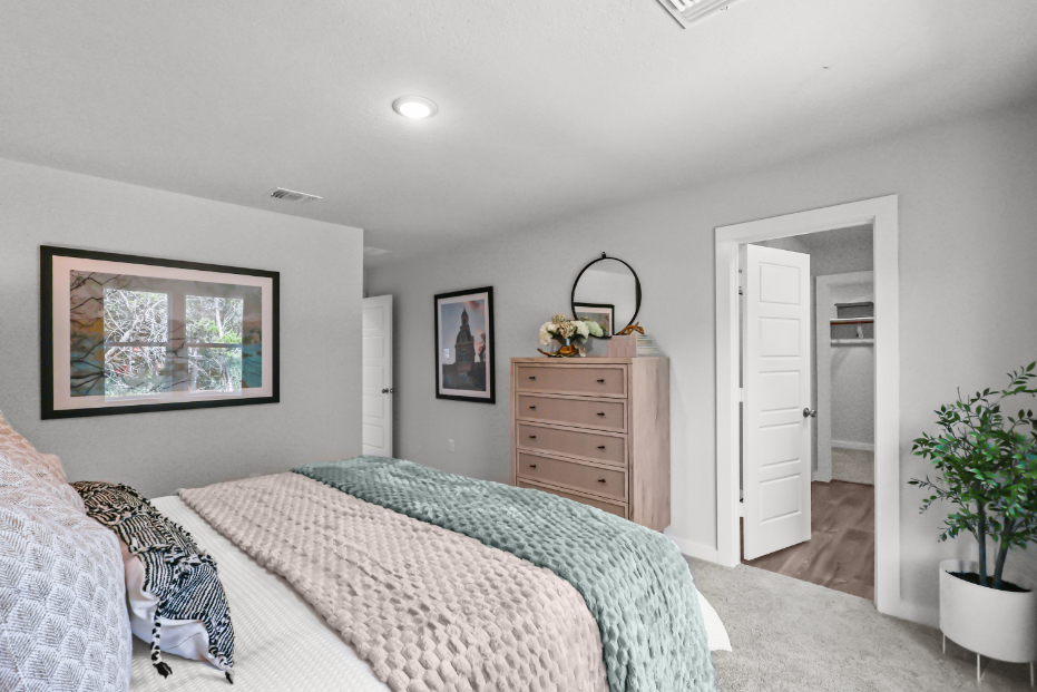 A bedroom with a bed and dresser.