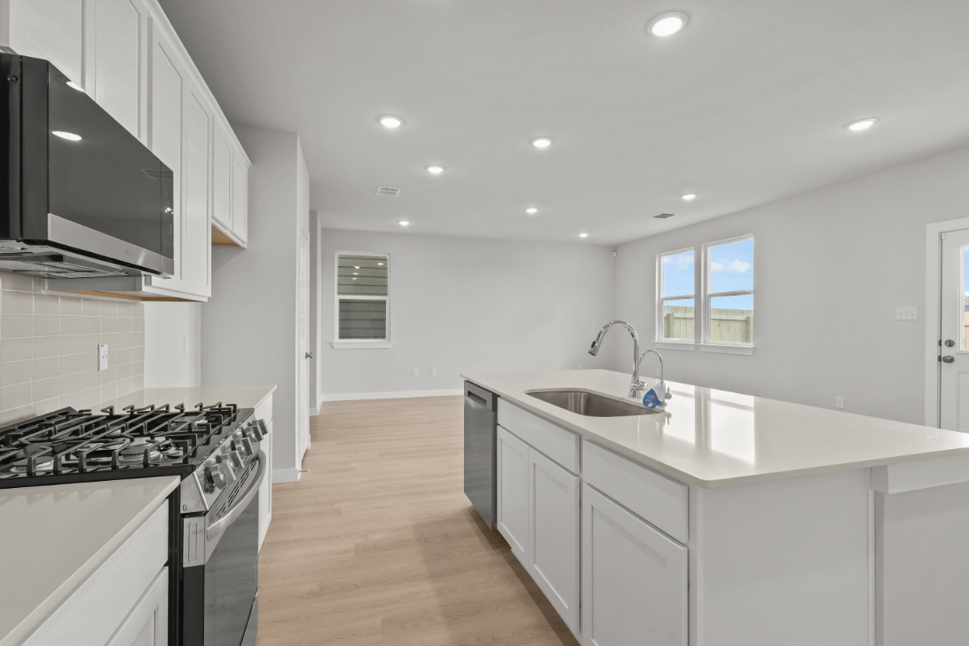 A kitchen with white cabinets.