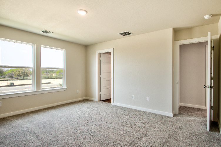 A room with a carpet and windows.