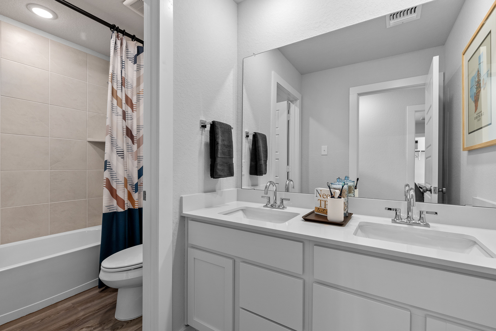 A bathroom with a sink toilet and mirror.
